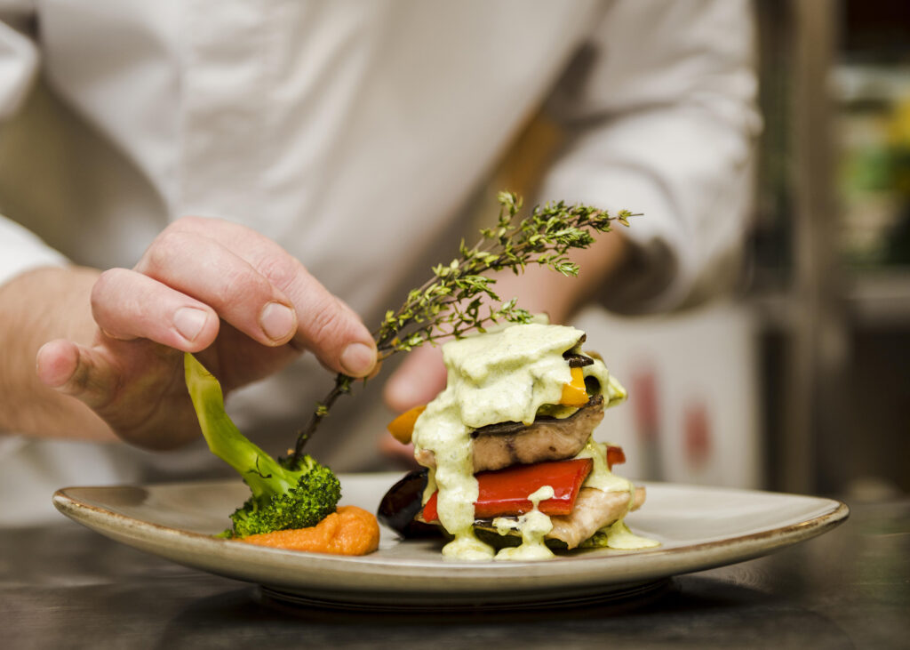 Plat gastronomique avec chef en arrière plan