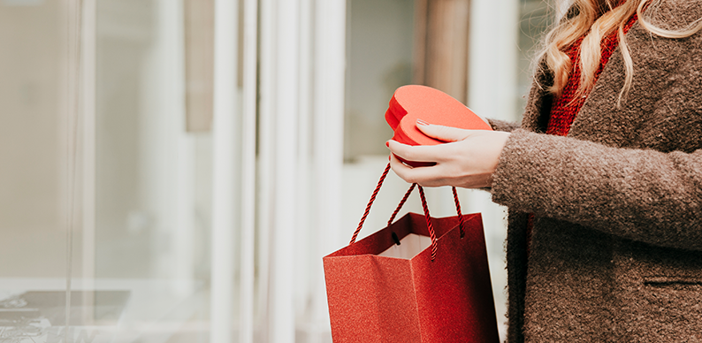 Femme avec un sac rouge faisant du shopping pour la saint valentin
