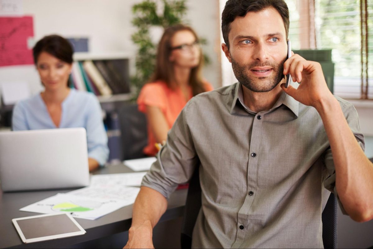 Photo d'un homme au téléphone assis à son bureau