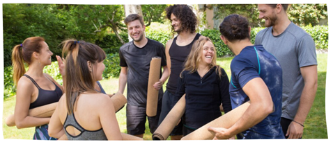 Groupe de jeunes gens en extérieur, avec des tapis et en tenue de sport.