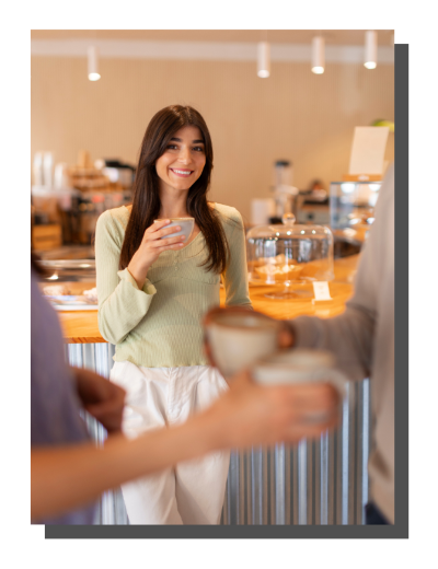 jeune femme souriant qui tient une tasse dans un café